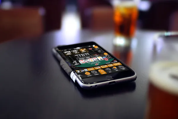 Um homem concentrado em seu laptop com estatísticas ao vivo ao fundo, destacando os recursos dedicados de esportes e jogos do app móvel 83BET.